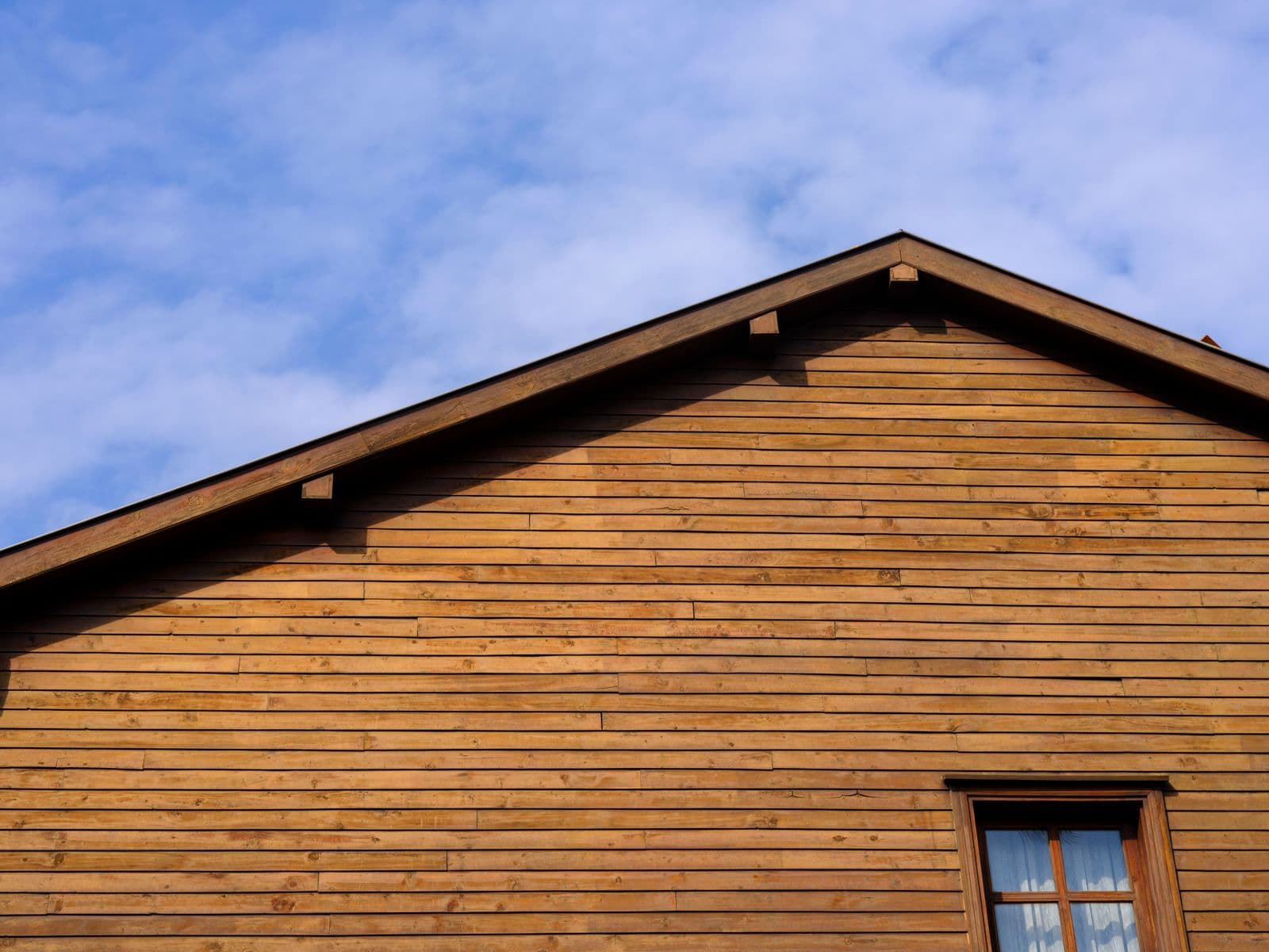 Gable end of a house clad in horizontal wood siding