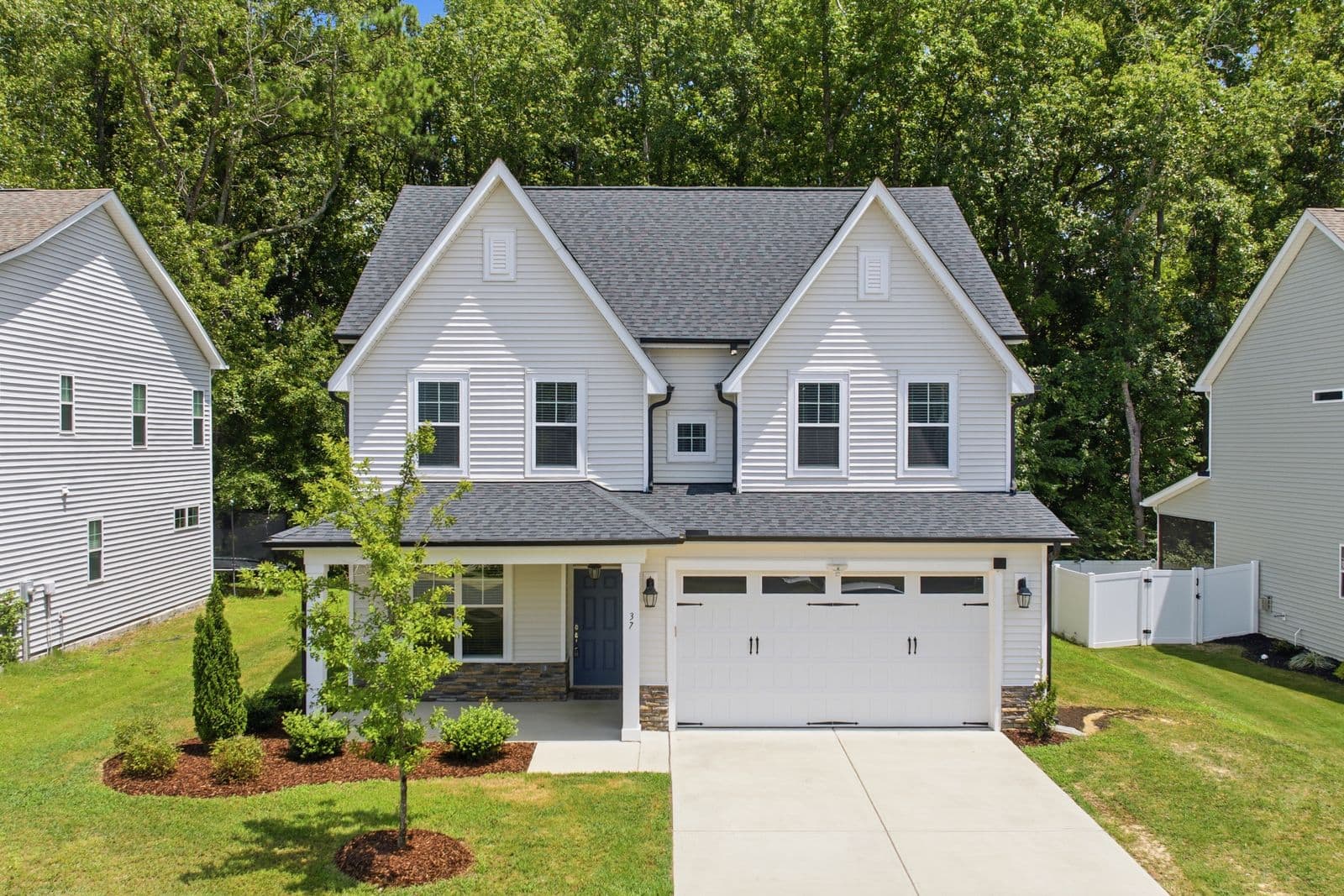 Two-story house with white siding and a white garage door
